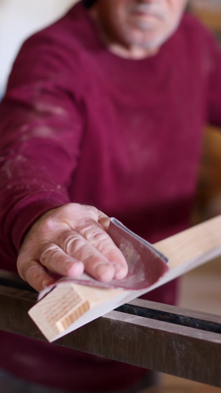 Primo piano della mano di un uomo che leviga il legno