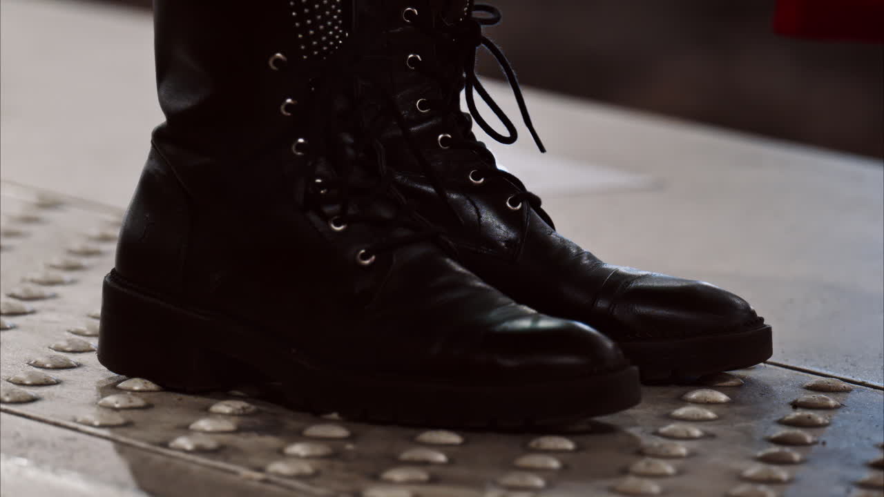 Close up of woman's boots on a Tactile pavement at the Monaco train station