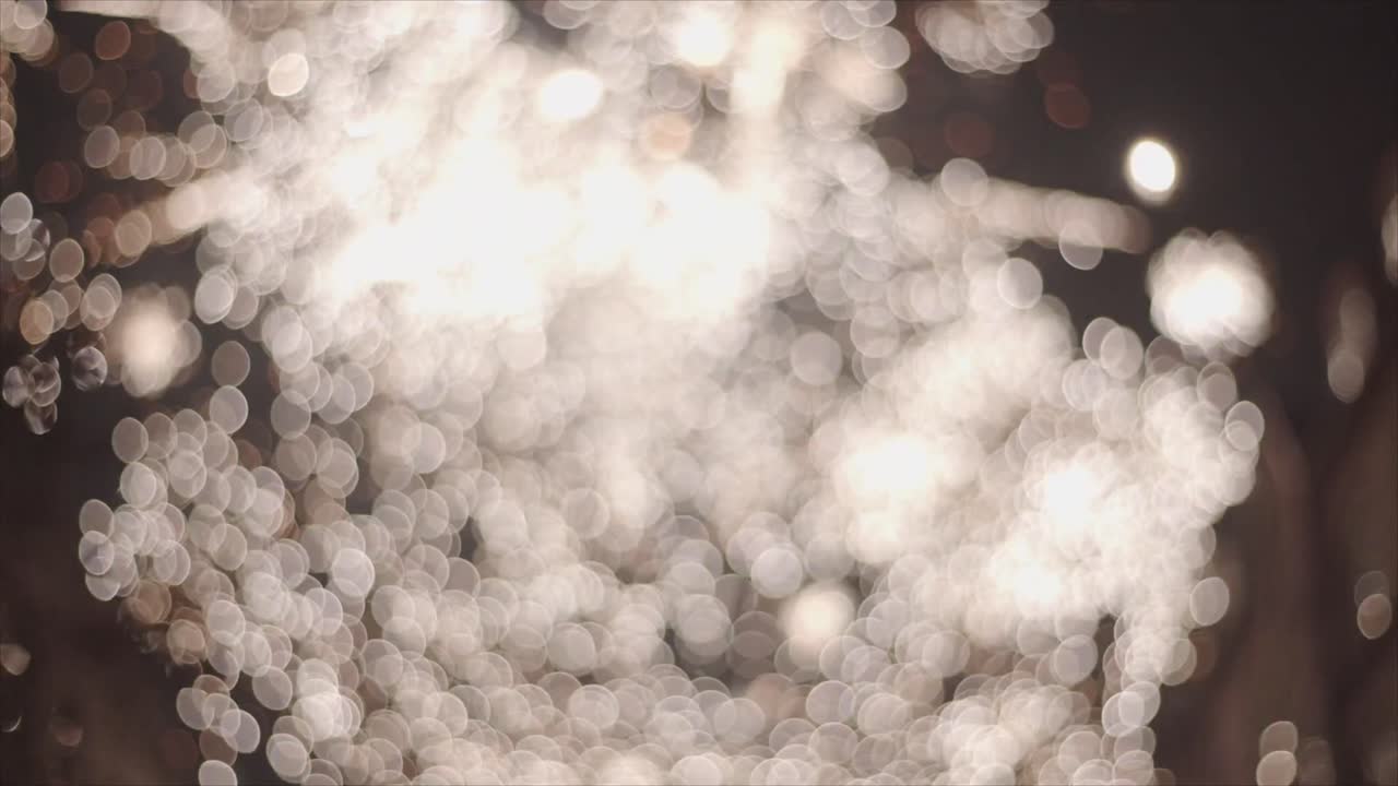Glitrende bokeh-lys som eksploderer mot en mørk bakgrunn