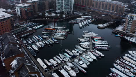 drone shot over limehouse waterside and marina boats in the snow london