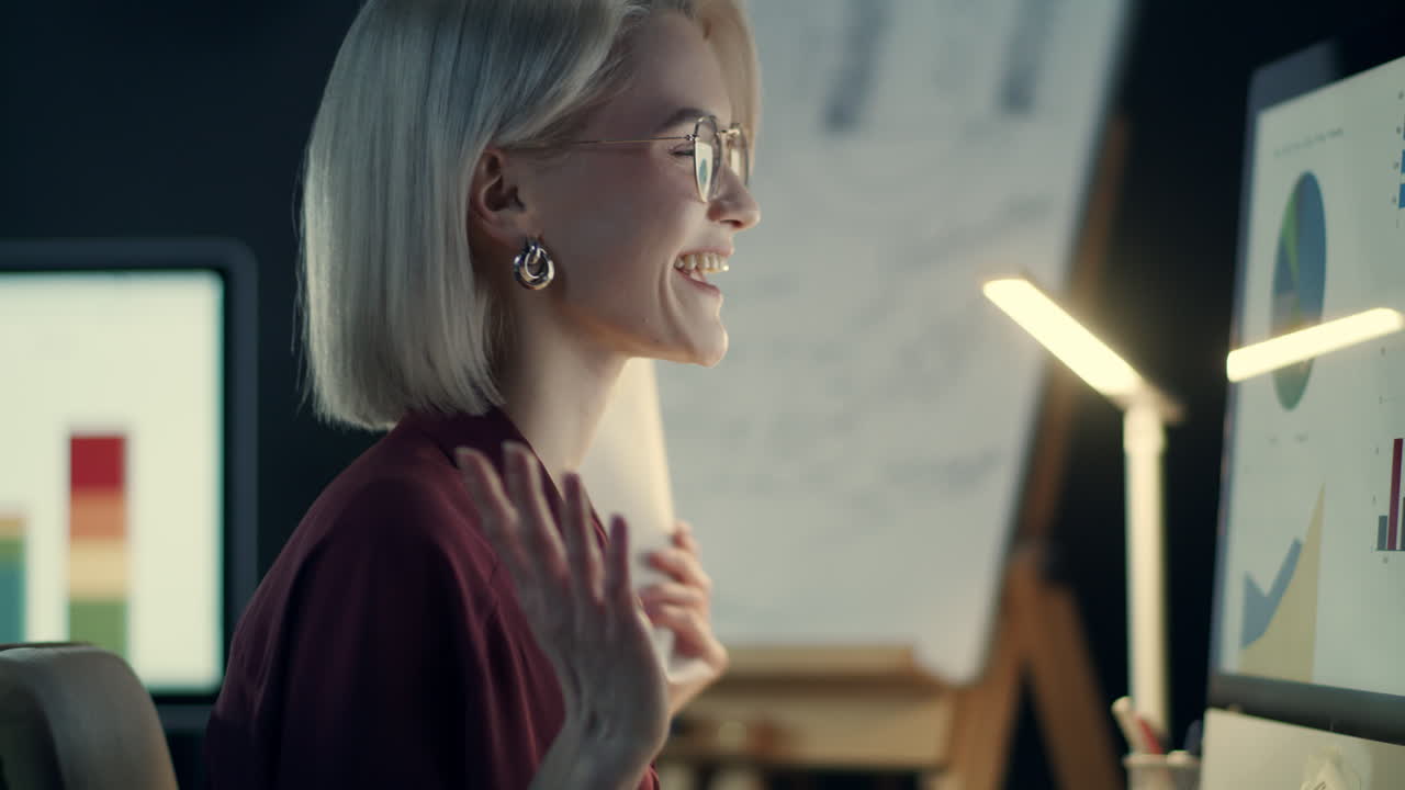 Primo piano di donna sorridente che lavora al computer in ufficio.
