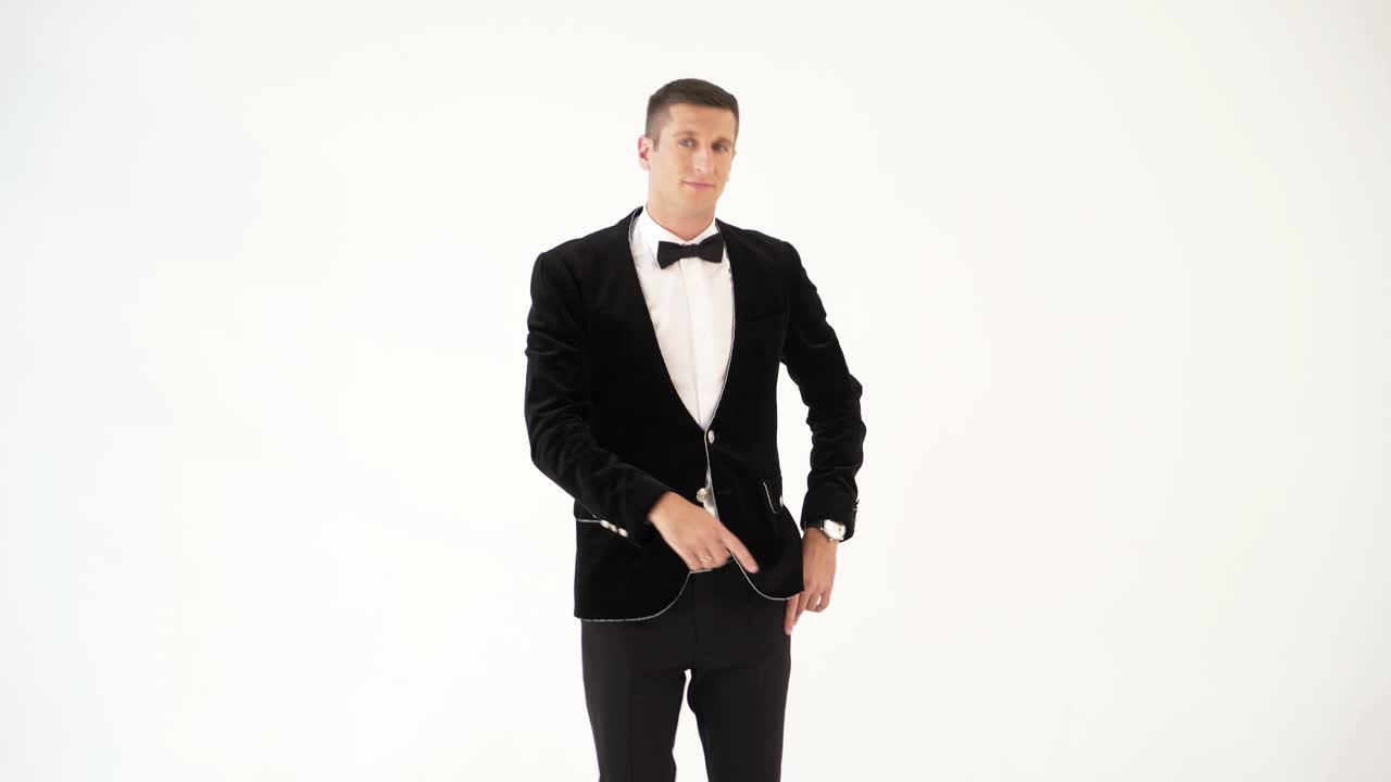 humorist in trendy costume is parodying a man who dancing in a club on a white background in the studio