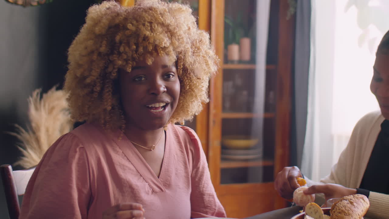 Joyous Black Woman Talking to Family at Holiday Dinner
