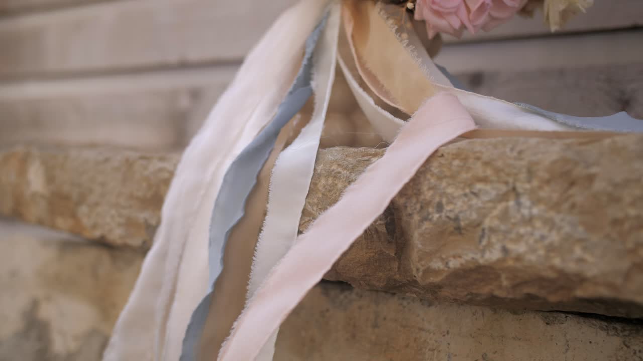elegante bouquet da sposa romantico con peonie e nastri pastello, inclinato verso il basso
