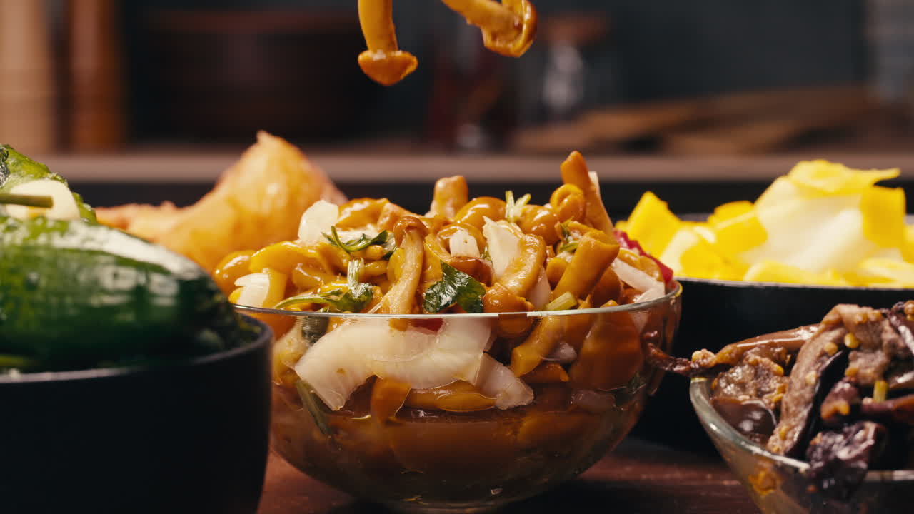 Taking a little bit of fermented yellow honeydew mushrooms with onion by chopsticks close-up. Preservation of vegetables in glass jars. Fermentation preserved mushroom with spices. Asian cuisine.