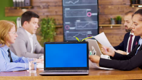 On-the-table-laptop-showing-blue-mock-up-screen