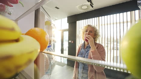 a woman takes fruit from the refrigerator