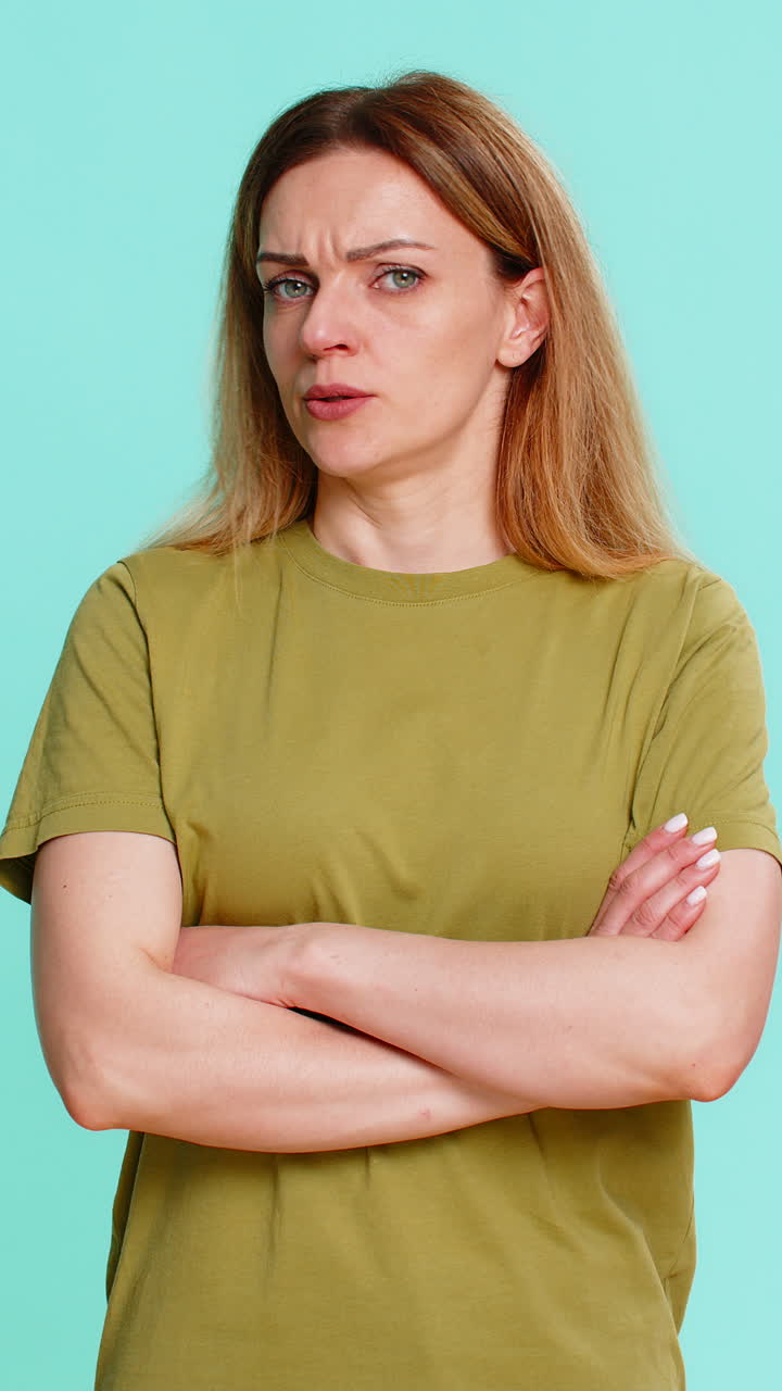 Adult woman crossing arms and staring seriously showing disagreement disapproval strong rejection