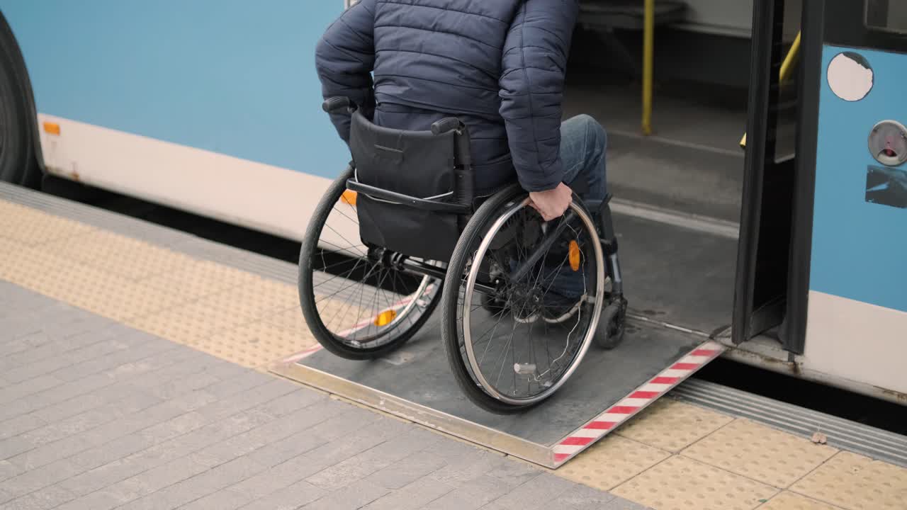 una persona con discapacidad física se sube al transporte público con una rampa accesible