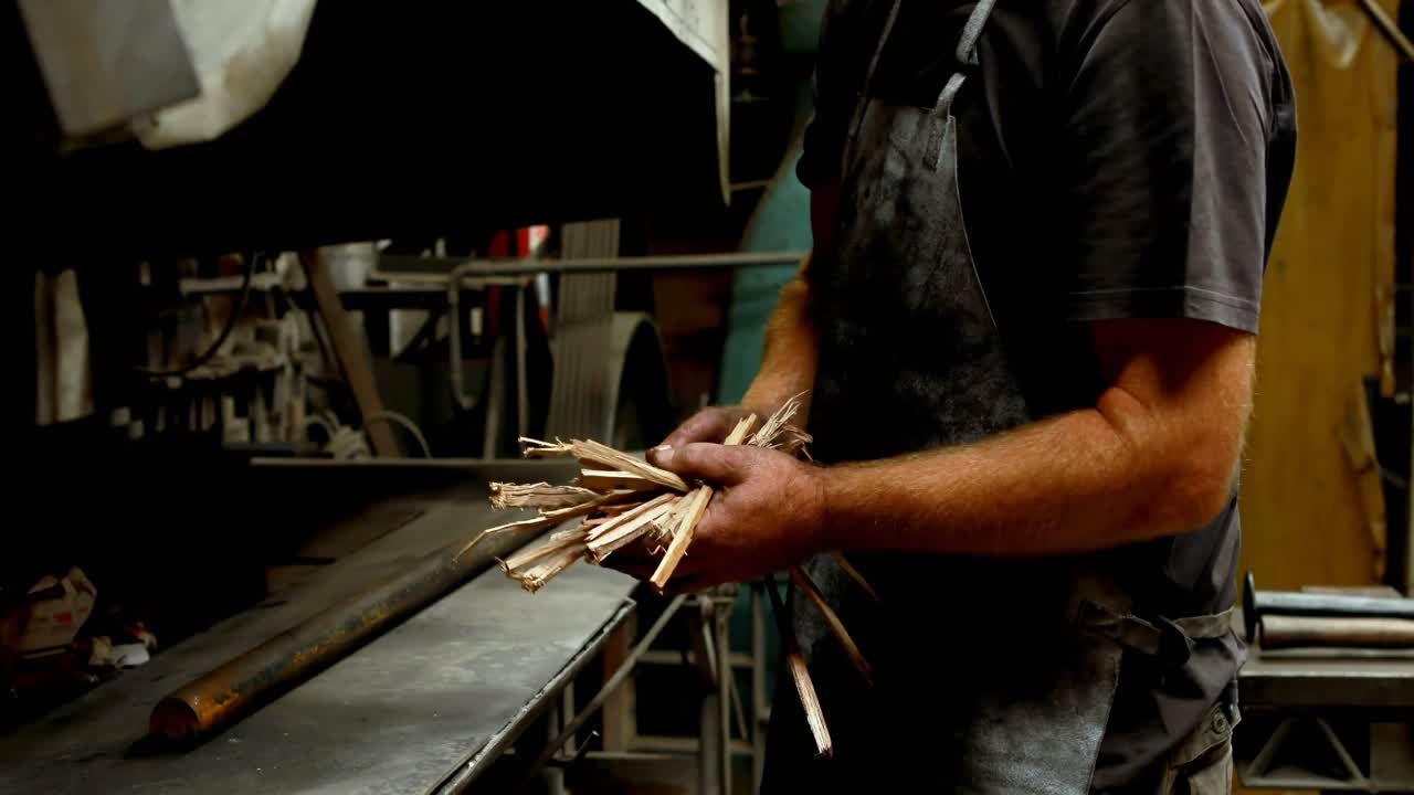 Blacksmith putting log sticks in fireplace 4k