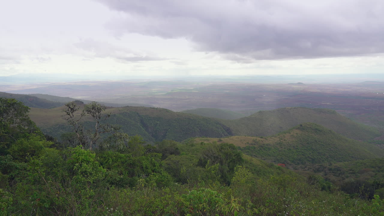 Rain falling on thick green mountainside overlooking the Great Rift Valley
