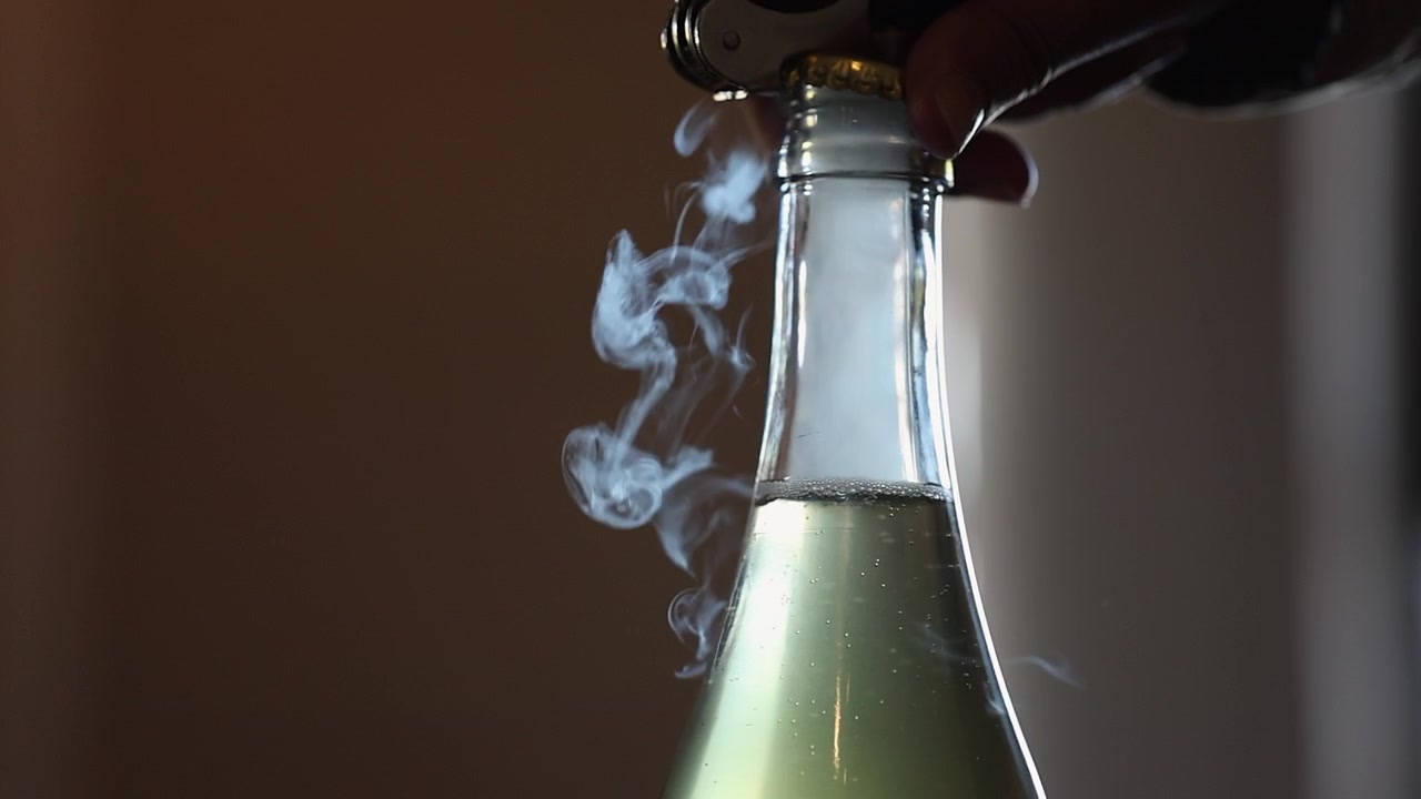Cận cảnh mở chai rượu táo trong suốt có ga, khí thoát ra dưới dạng hơi