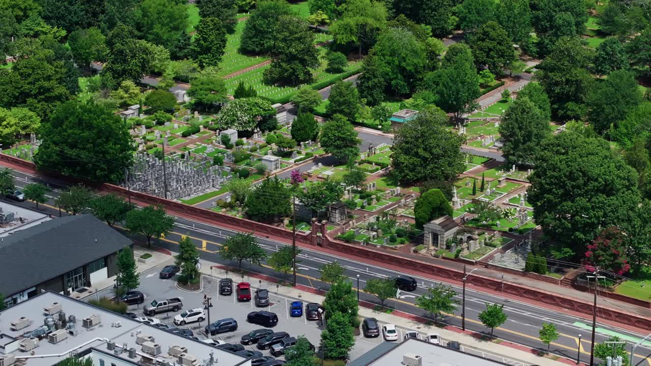 Driving cars on street near peaceful cemetery in Atlanta, USA. Aerial view. Sunny summer day with graveyards and tombstones