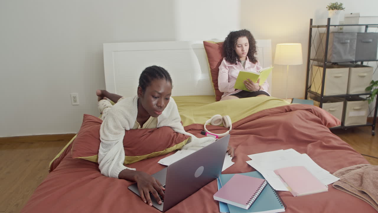 Female Roommates Preparing for Exam in Bed