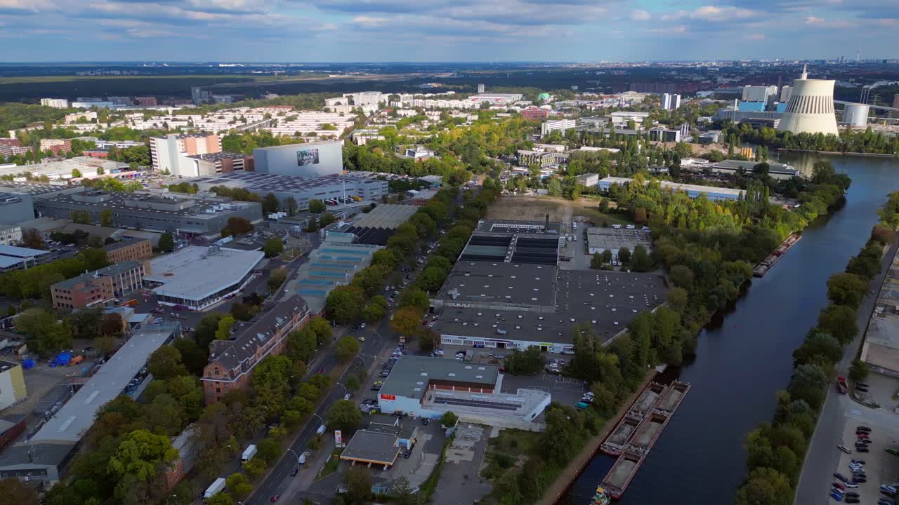Industrial landscape with factories, a large power plant, and storage tanks bordering river in berlin germany. Dramatic aerial view flight panorama overview drone
