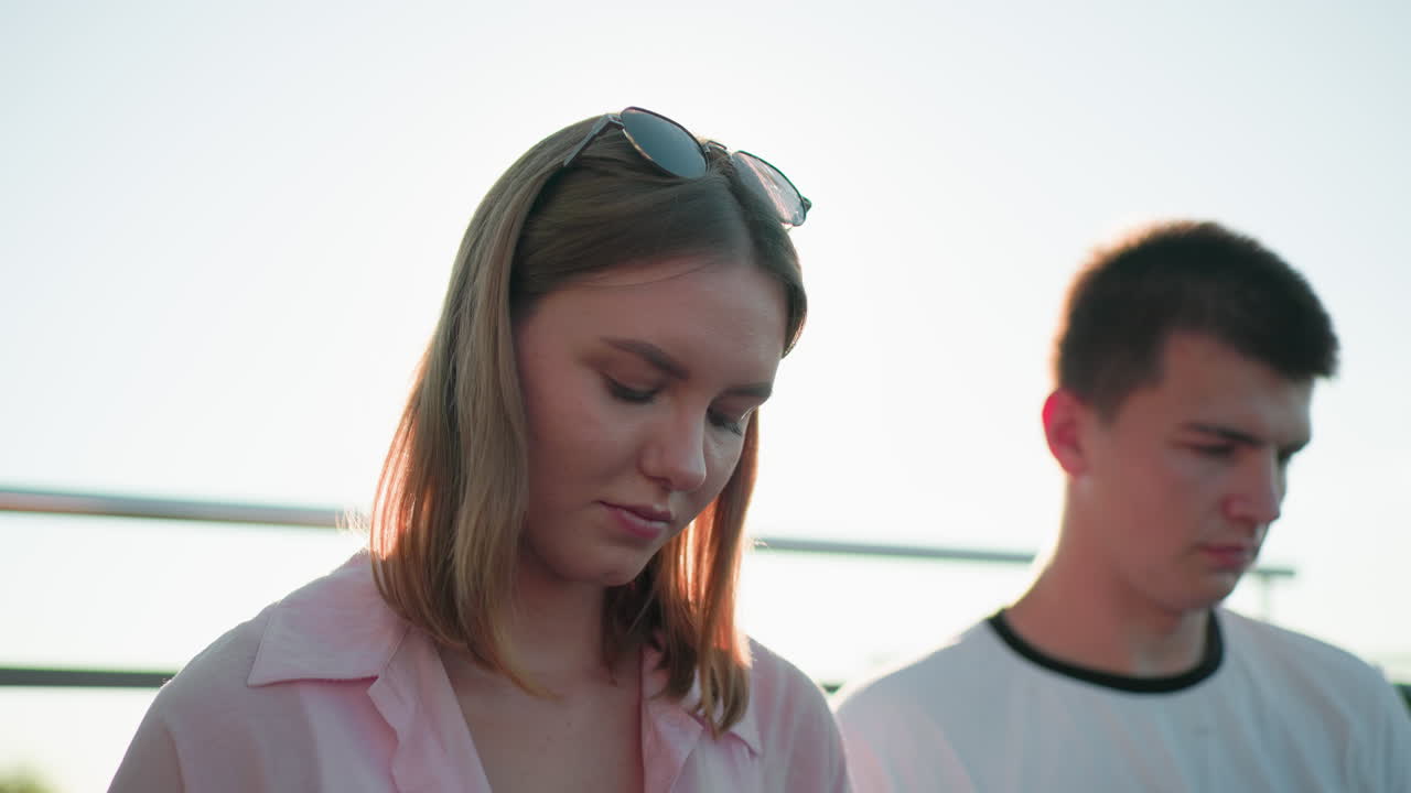 머리에 안경을 쓴 분홍색 셔츠를 입은 어린 소녀, 빛의 홀로 효과, 그녀의 에 집중된 젊은 남성, 레일링과 흐릿한 초록색 배경