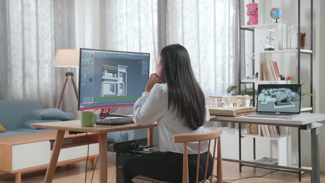 ingegnere donna asiatica che pensa poi sollevando l'indice mentre progetta la casa su un desktop a casa. giochi informatici progettazione e decorazione della casa