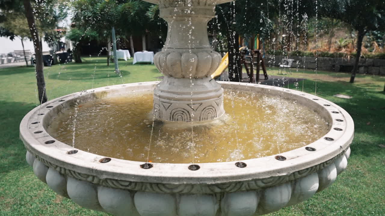 fuente de piedra esculpida en un jardín iluminado por el sol
