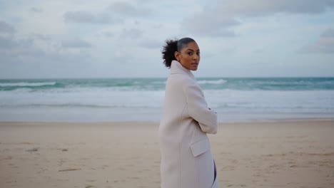 Lonely-girl-posing-ocean-beach-waves.-Serious-black-hair-woman-enjoy-solitude