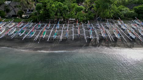 drone panning view of many traditional fish boats on a beach