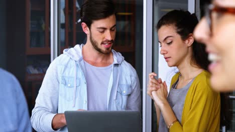 Executives-discussing-over-laptop