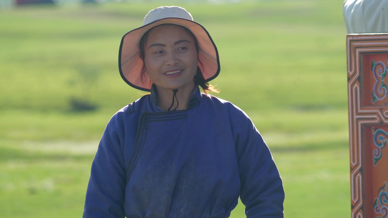 屋外で微笑む伝統衣装のモンゴル人女性。