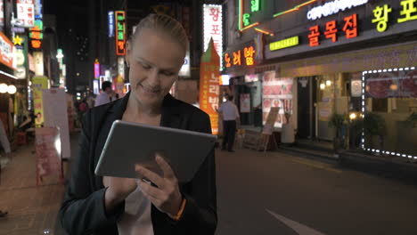 woman using touch pad in the street of seoul at night south korea