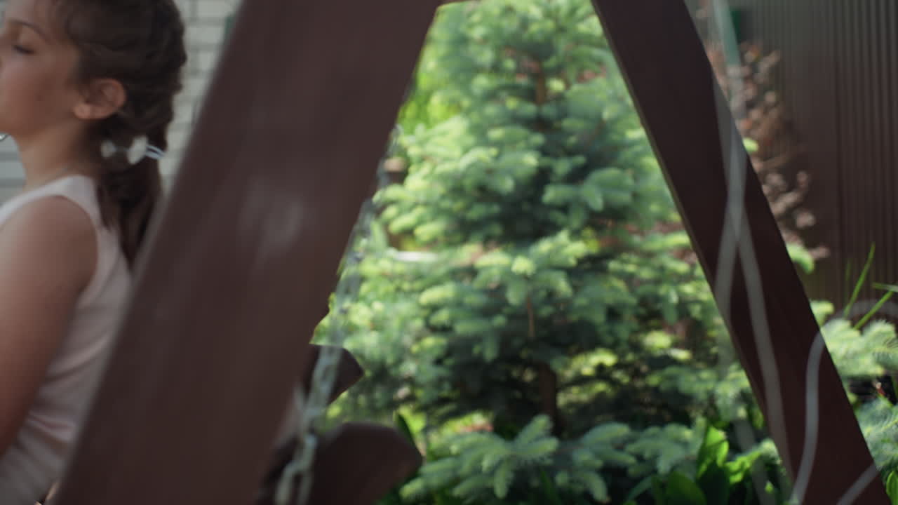Girl By Swing, Youthful Woman Resting Near Outdoor Swing, Young Female In Serene Garden With Wooden Swing Frame, Adolescent Girl Posing Softly Amidst Lush Greenery Next To Rustic Wooden Swing