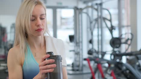 woman at gym taking a protein shake