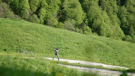 在鄉村山道上徒步旅行的千禧一代白人背包客的放大镜头