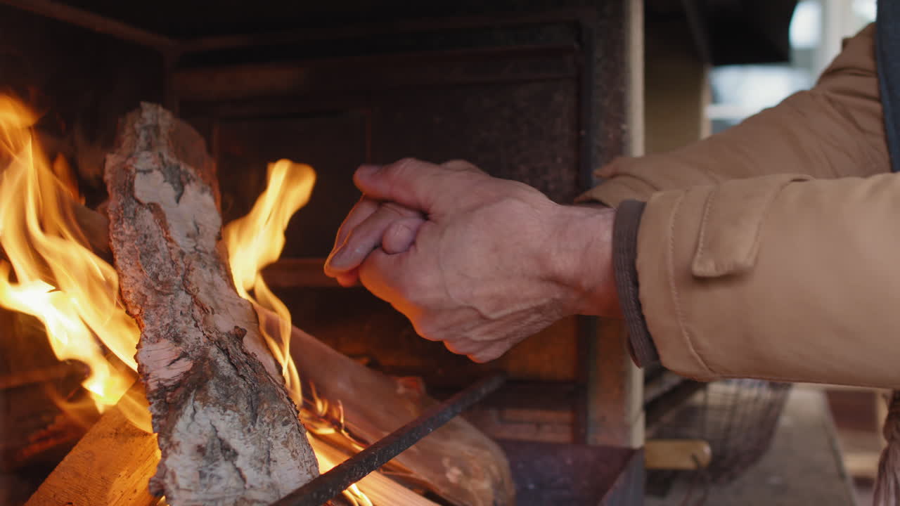 Unrecognizable Man Warming Hands by Fire in Fireplace