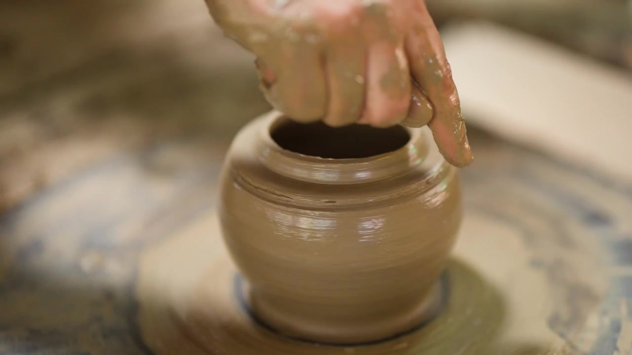 Primo piano delle mani di un vasaio che modellano argilla bagnata in un vaso di ceramica a Nonthaburi, Thailandia.