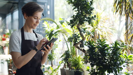 woman florist using tablet in shop