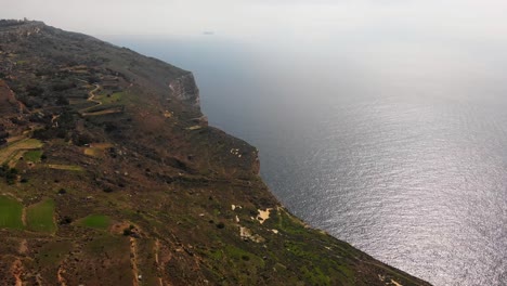 Impressive-aerial-video-from-west-of-Malta,-Dingli-area-turning-from-the-land-towards-the-steep-and-high-cliffs