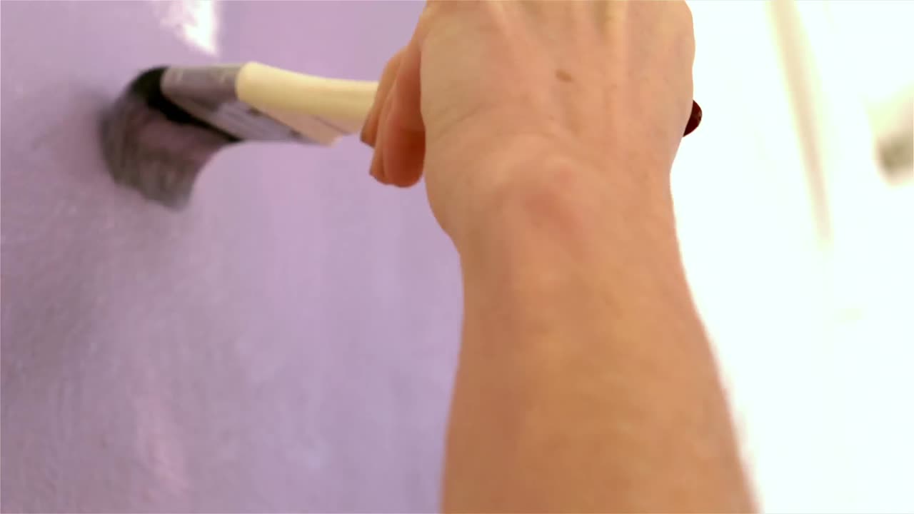 женщина восстанавливает стену кистью