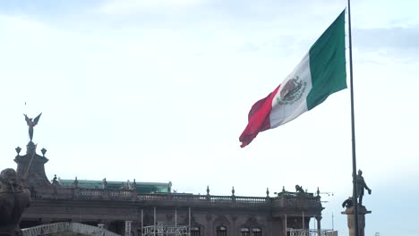 mexican flag slow motion waving in windy day with against clear blue sky