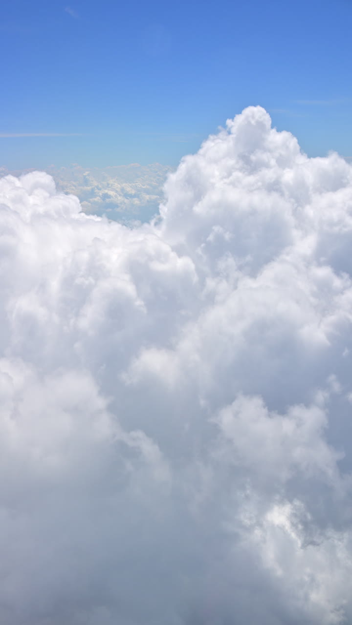 View of the clouds from an airplane window. Vertical