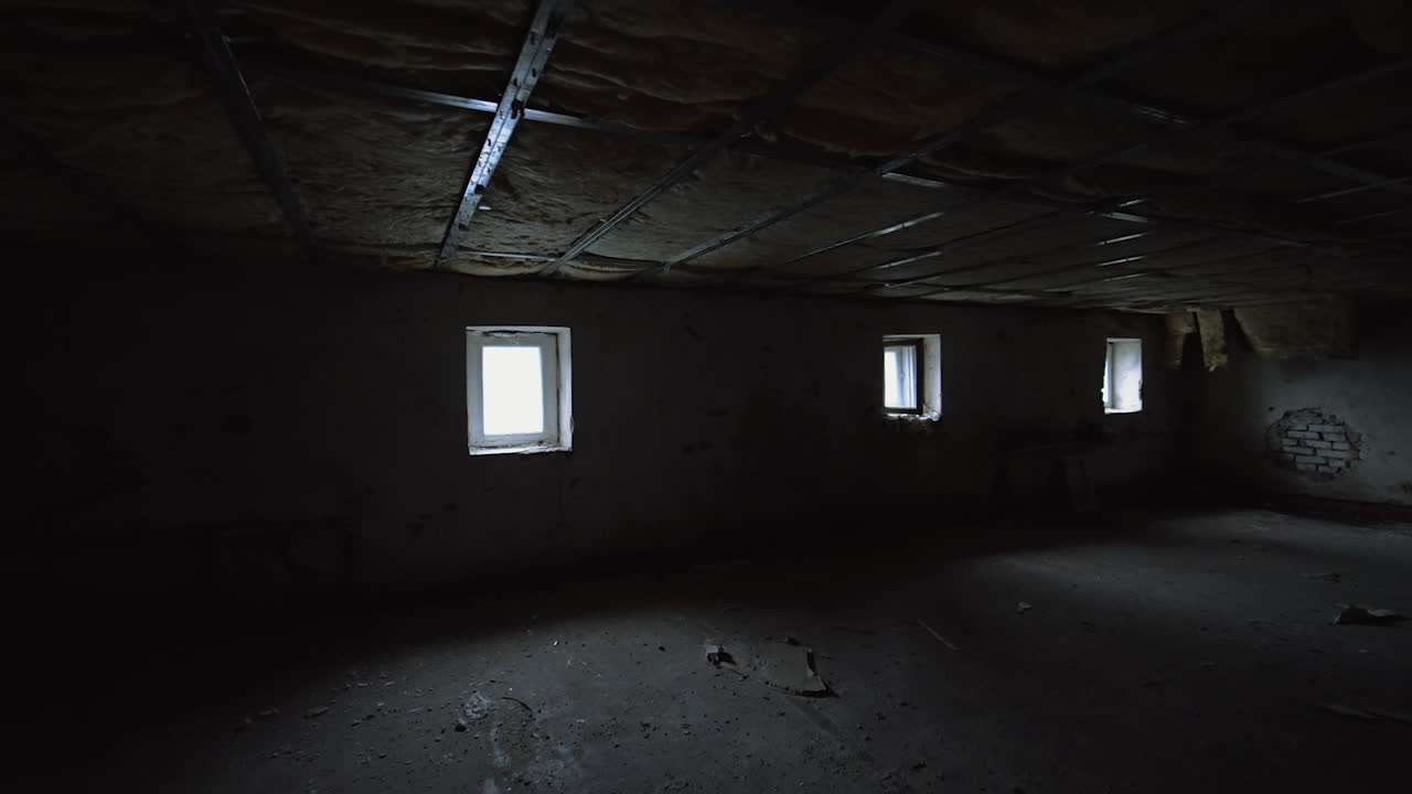 Being inside the large dark room with little windows. Low angle view on the insulated ceiling of the basement.