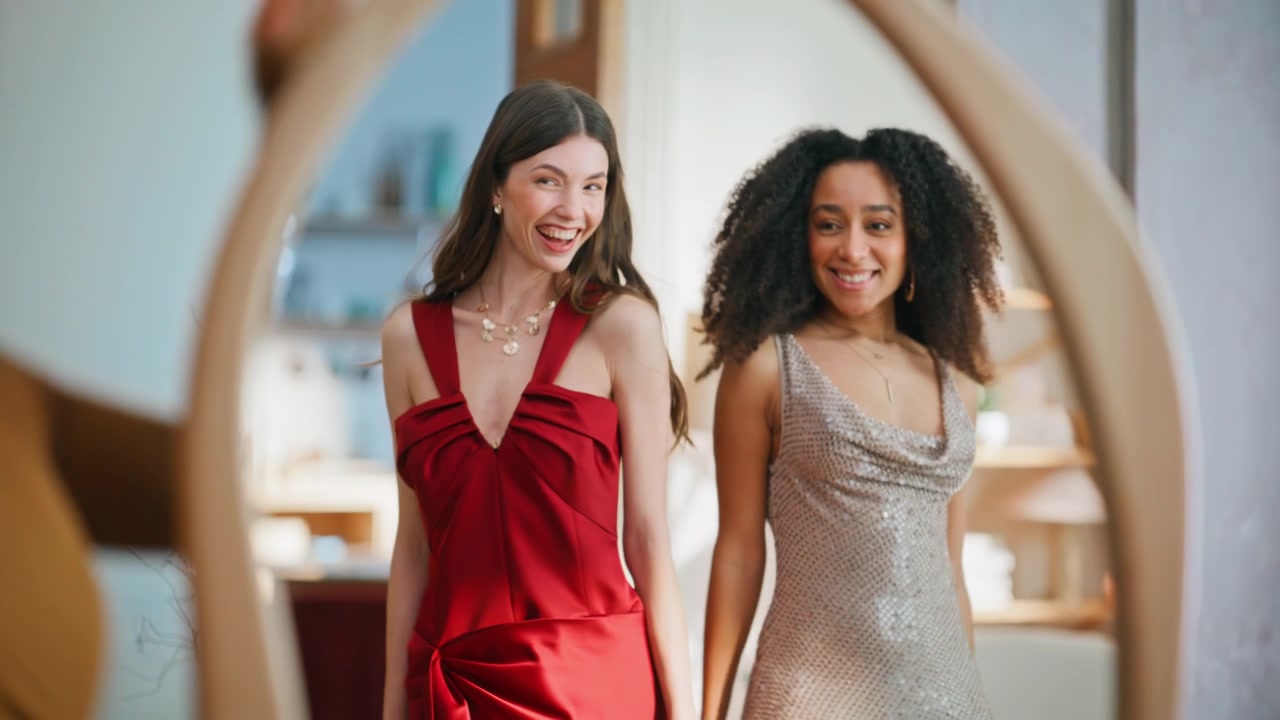 Femme réagissant à la tenue de ses amies, debout devant un miroir à la maison, en gros plan. Dames élégantes et heureuses