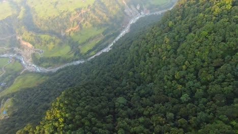 el drone holandés cae a través de la cresta del valle para revelar el río serpenteante en pokhara, nepal.
