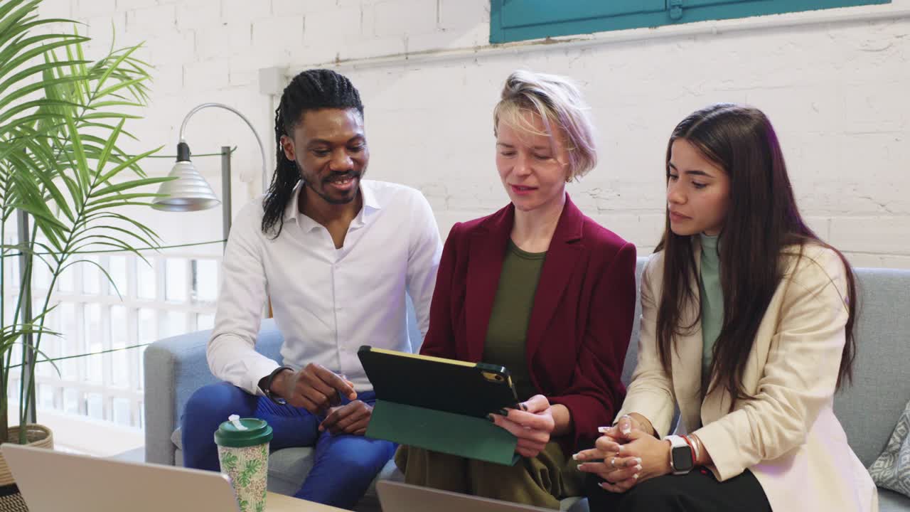Three businesspeople collaborating using a tablet