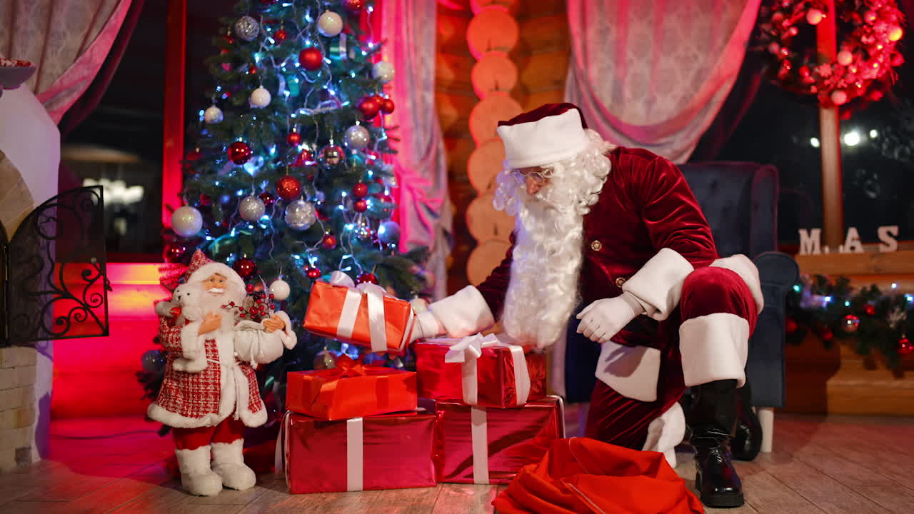 Christmas gifts. Santa Claus putting presents under the Christmas tree at New Year's eve.Santa with presents near at decorated Christmas tree near fireplace.