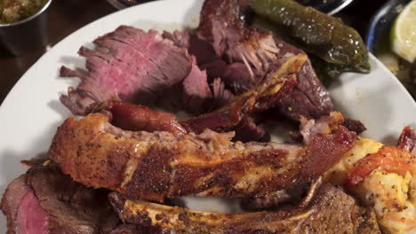 fork takes a bite medium well steak from overfilled plate of meat, push slide 4k