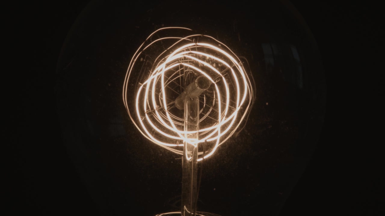 Primo piano dell'interno intricato di una lampadina su sfondo nero