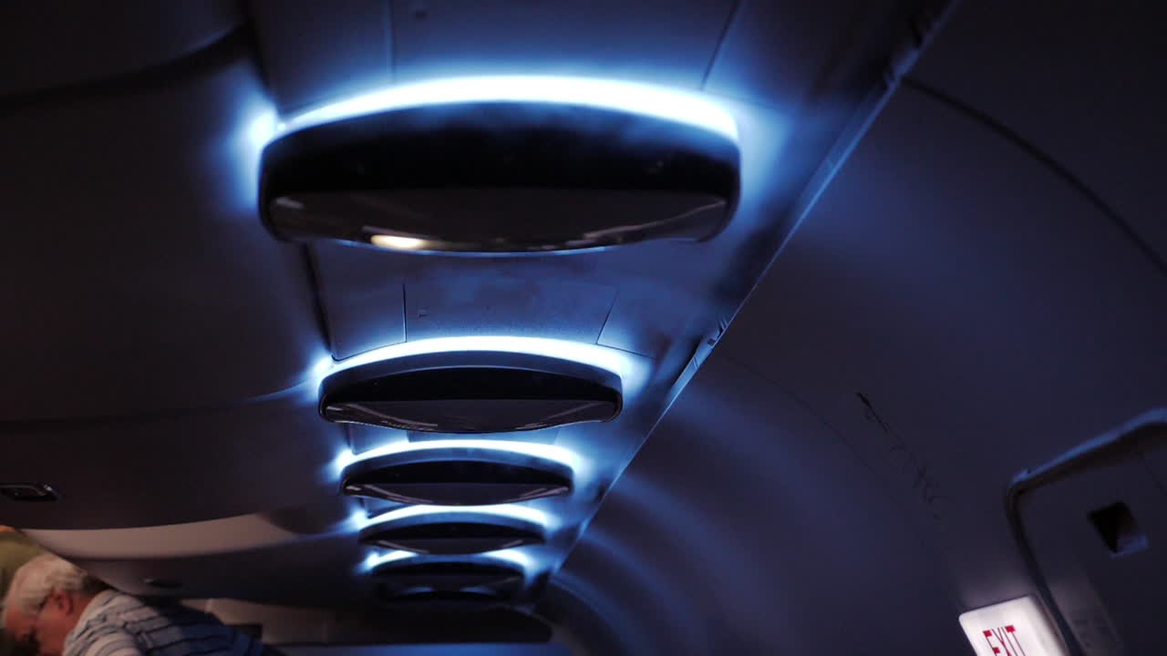 Water vapor coming out of the vents inside the cabin of a passenger airliner in slow motion.