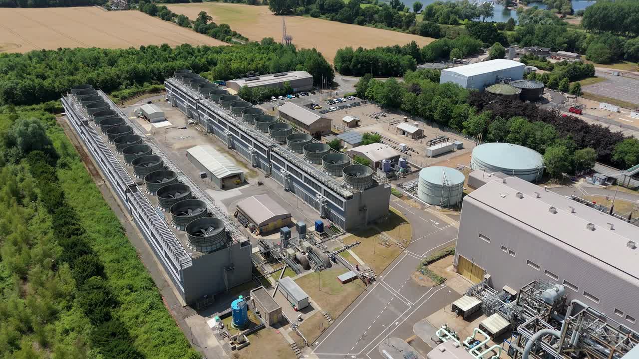 Sommerhimmel over et energiproduktionsanlæg.
