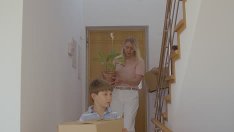 happy family entering new house with cardboard boxes