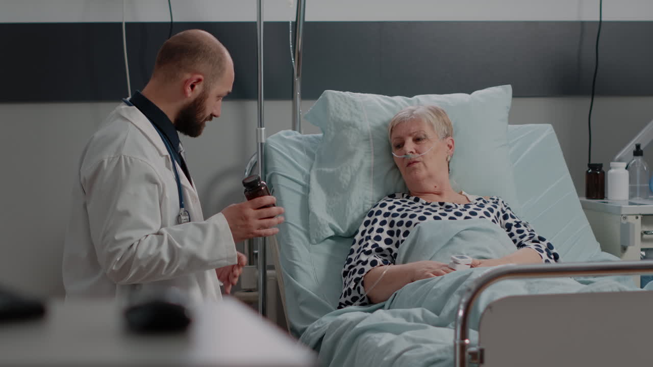 Dottore che tiene in mano un flacone di pillole e spiega il trattamento