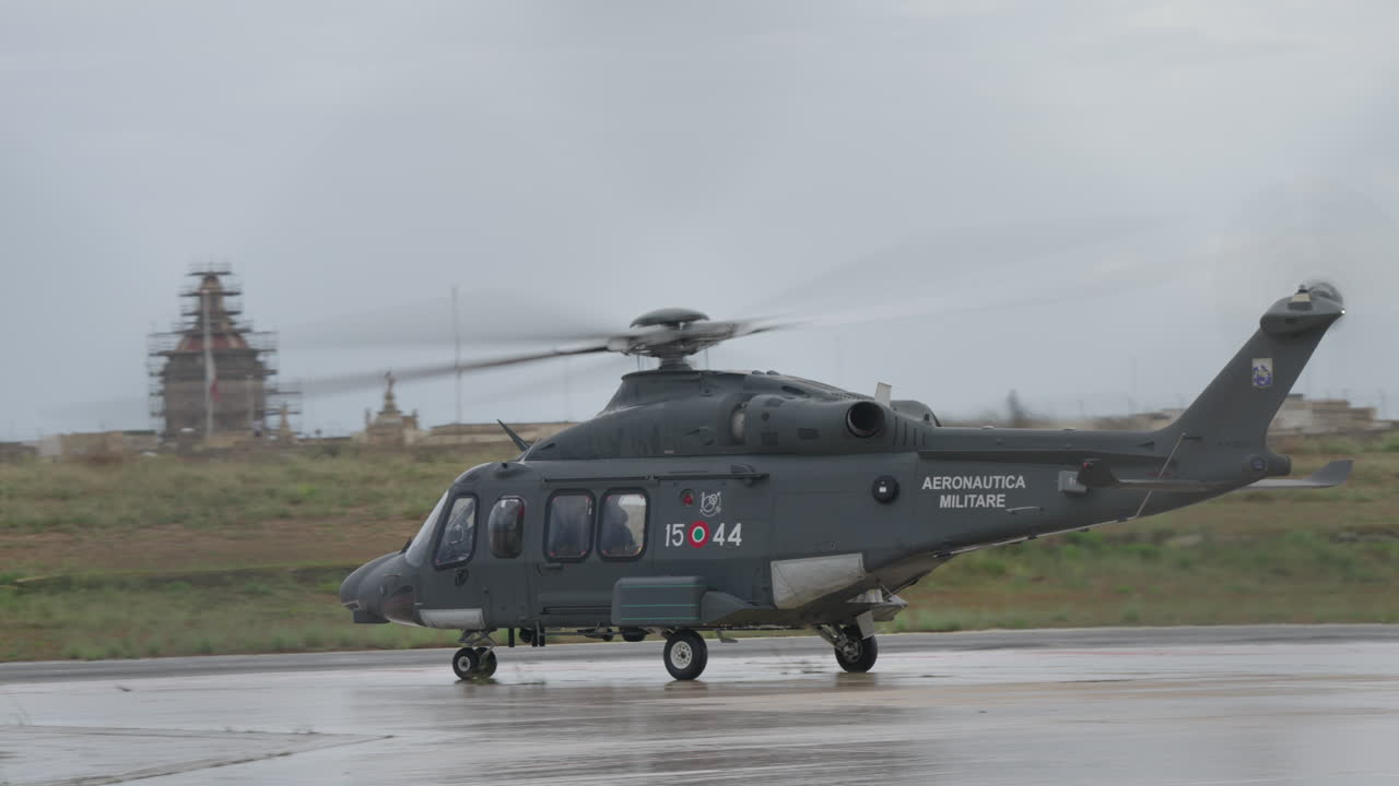 濡れた滑走路をタキシングするイタリア空軍の軍用ヘリコプター