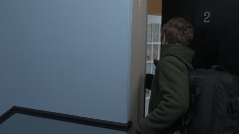 Man-puts-on-cycling-helmet-leaving-apartment